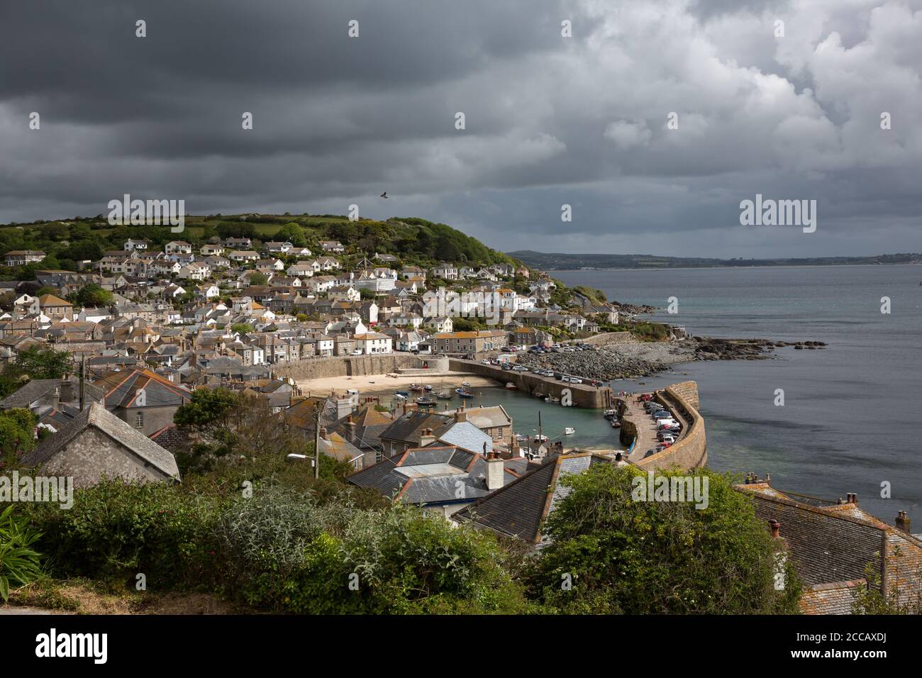 Dunkle Wolken über Mousehole Harbour in Cornwall UK Stockfoto