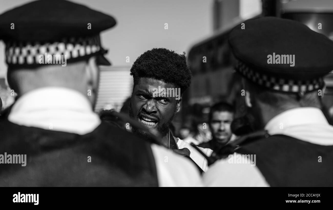 Ein Protestler hat eine hitzige Debatte mit der britischen Met. Polizei. Stockfoto