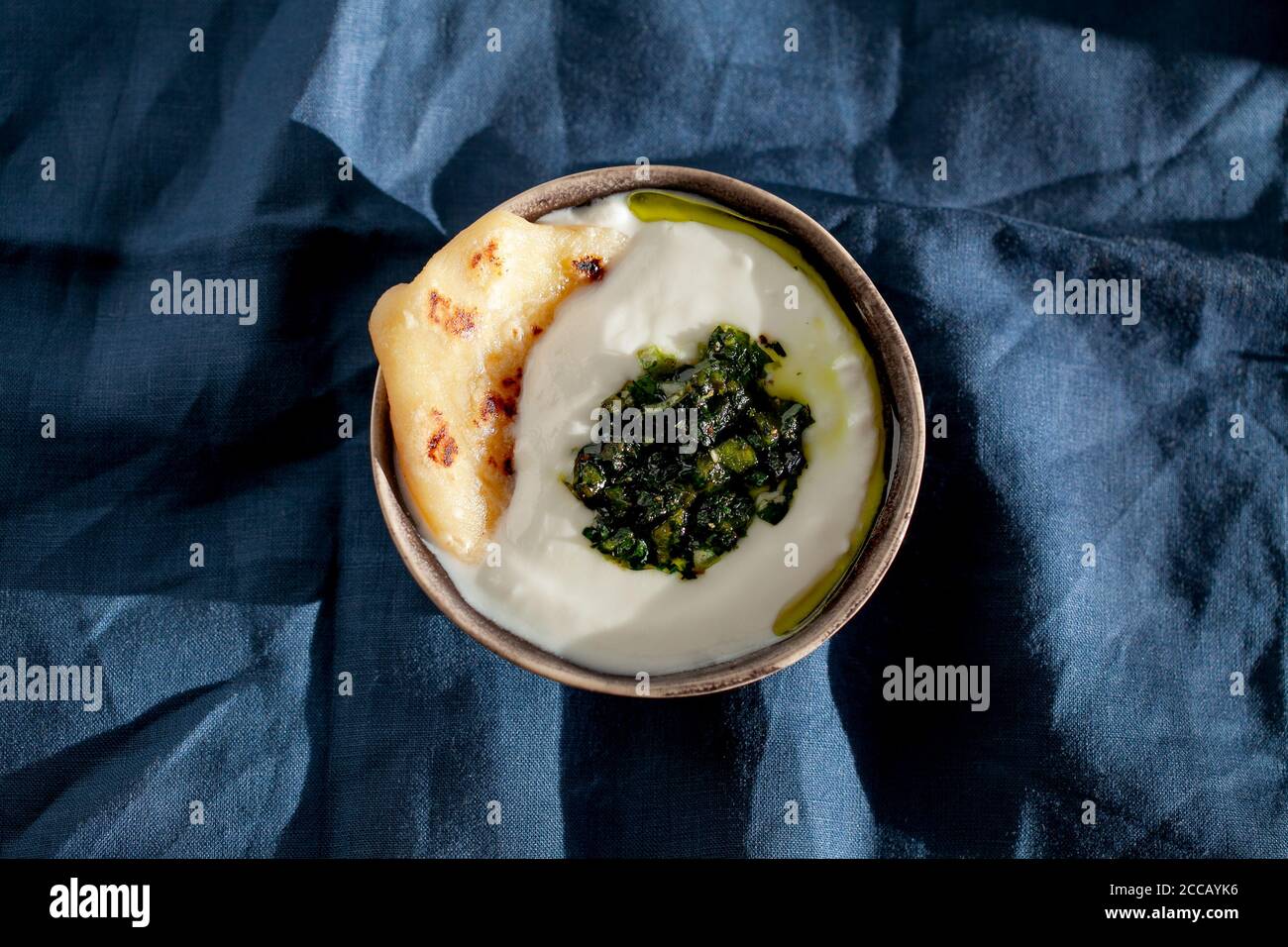 Indische grüne Minze und Petersilie-Chutney mit Paratha und Buttermilch-Joghurt in Keramikschale Draufsicht. Authentisches vegetarisches Essen Stillleben. Stockfoto