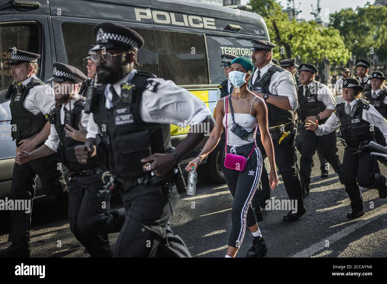 Traf Polizisten eilen an einem BLM-Protestler in London während der Lockdown vorbei. Stockfoto