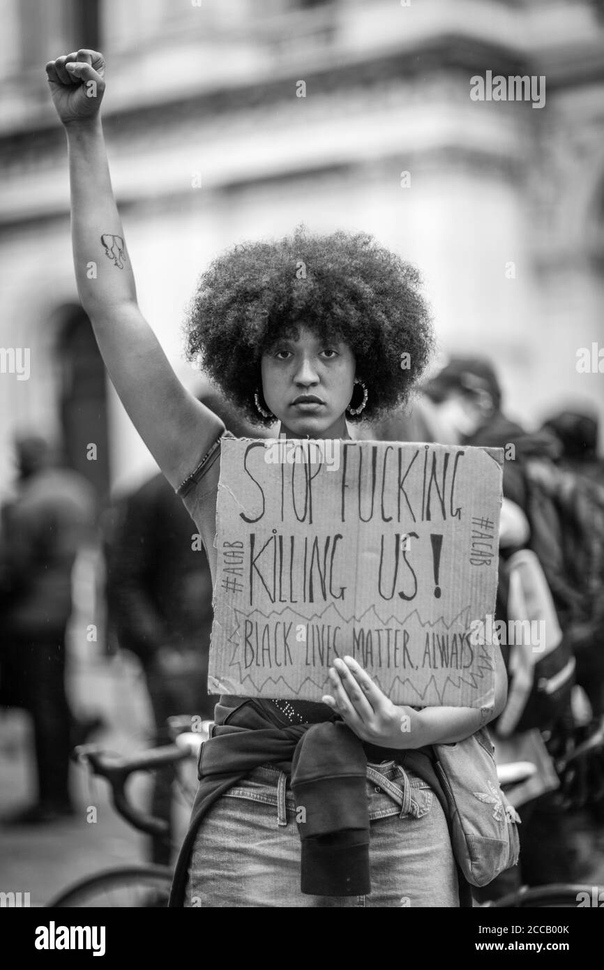 Ein Protestler hält ein Plakat hoch und eine aufgezogene geballte Faust symbolisiert Einheit, Stärke, Trotz oder Widerstand bei einer Black Lives Matter in London. Stockfoto
