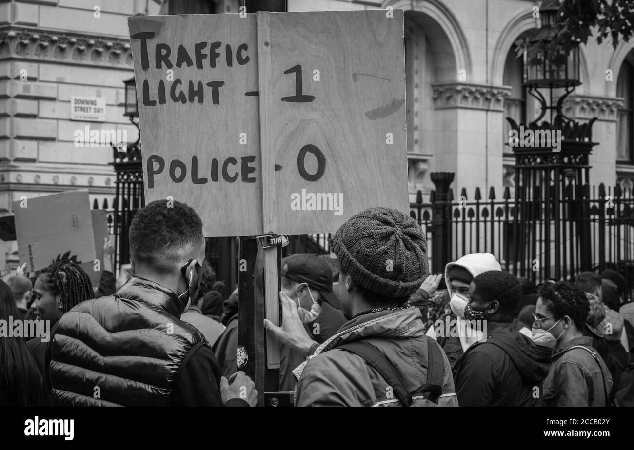 Demonstranten setzten ein Schild auf, das einem Polizisten zu Pferd folgte, der vor der Downing Street in London mit einer Ampel kollidierte. Stockfoto