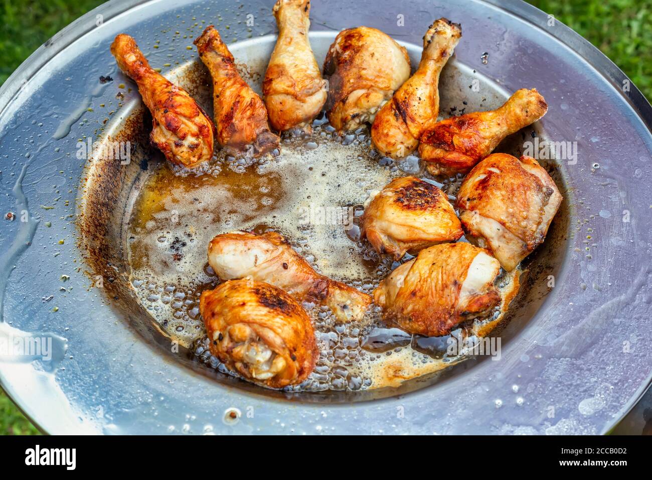 Hähnchenbraten in heißem Öl Teller. Gebratene Hähnchenschenkel mit knuspriger goldbrauner Haut, selektiver Konzentration. Stockfoto