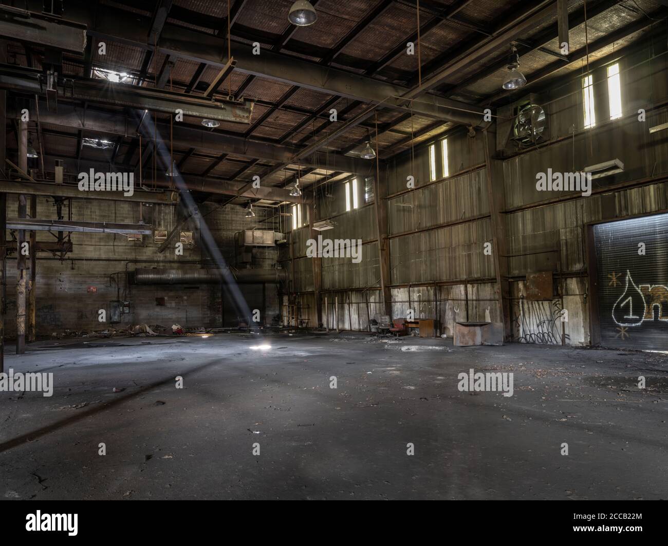 Lichtschimmer, der in die verlassene Fabrik, Conshohocken, Pennsylvania, USA, herabstrahlt Stockfoto