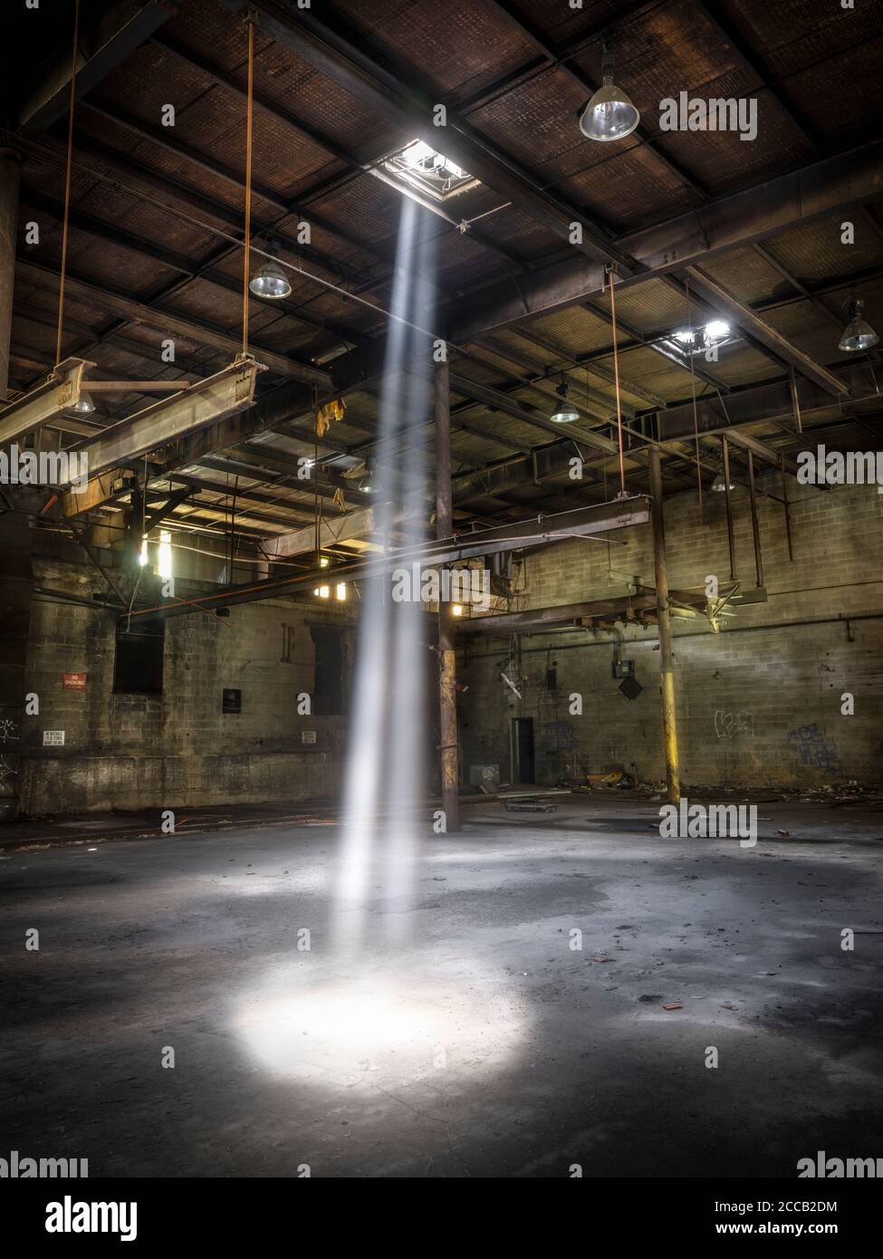 Lichtschimmer, der in die verlassene Fabrik, Conshohocken, Pennsylvania, USA, herabstrahlt Stockfoto