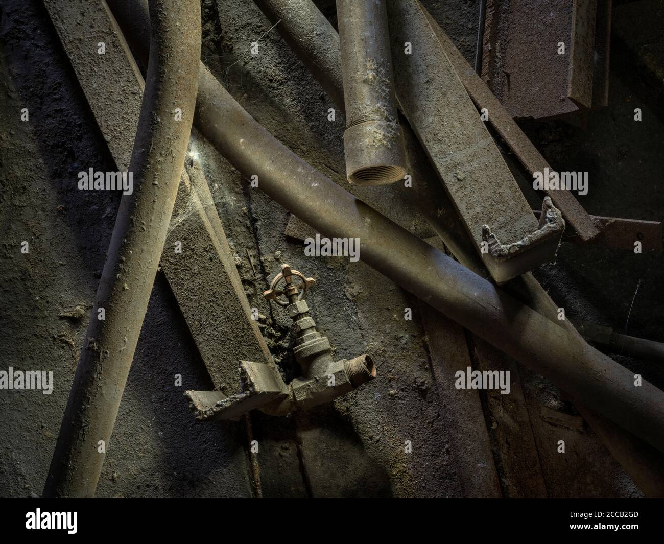 Haufen staubiger, schmutziger rostiger Rohre auf dem Boden einer verlassenen Fabrik, Conshohocken, Pennsylvania, USA Stockfoto