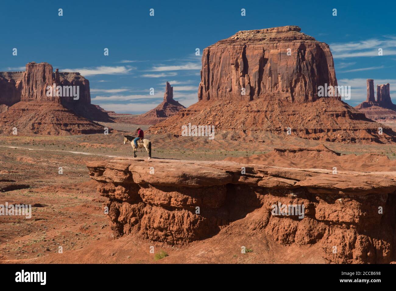Ein Navajo-Mann posiert auf einem Pferd auf einer Kante in Monument Valley, Utah, USA Stockfoto