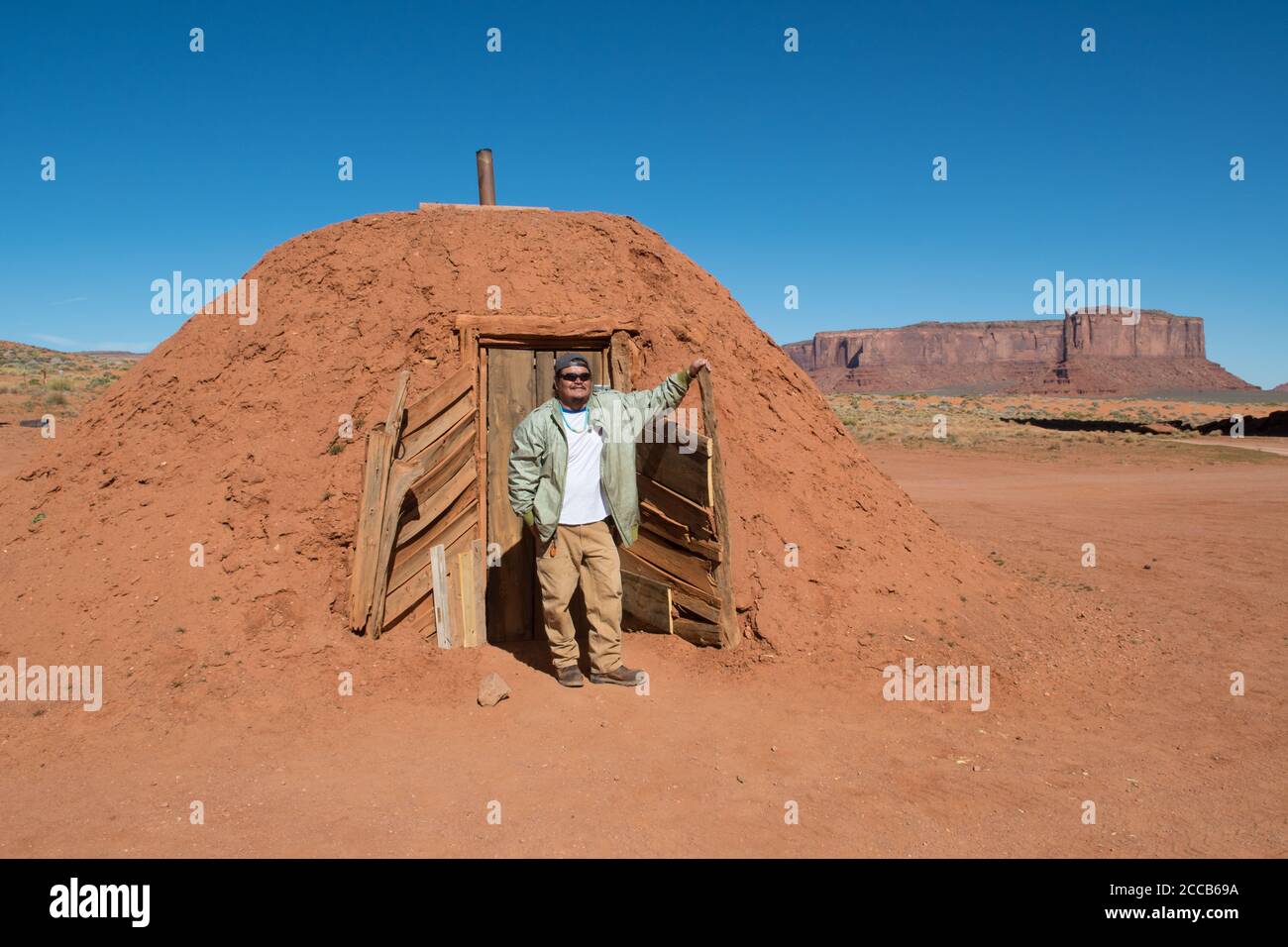 Ein Navajo-Reiseleiter steht vor dem hogan, in dem er aufgewachsen ist, Monument Valley, Utah, USA Stockfoto