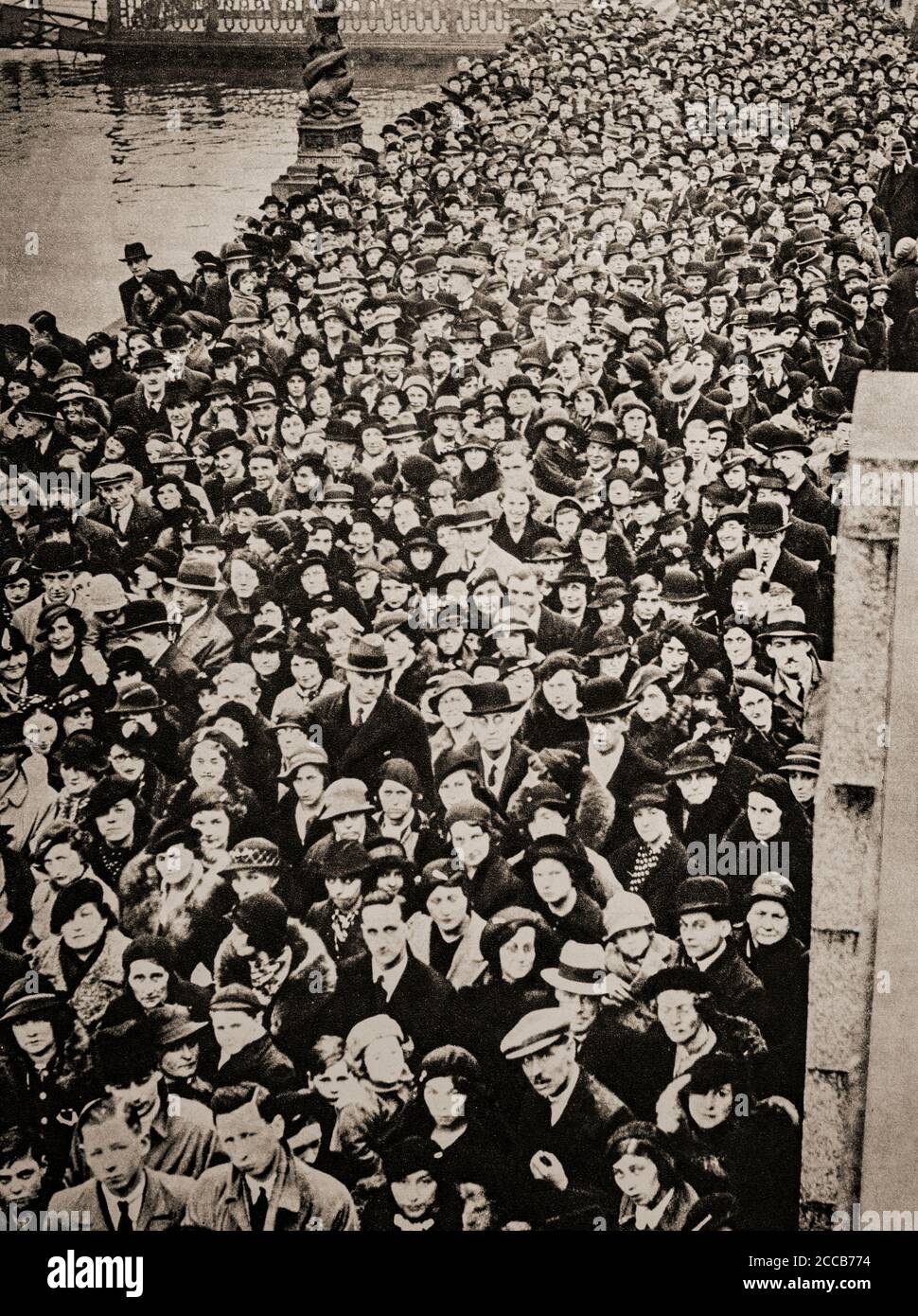 Nach dem Tod von König George V. am 20. Januar 1936 versammeln sich Massen auf der Westminster Bridge und warten auf eine Gelegenheit, den Sarg des Monarchen zu passieren, der in der Westminster Hall, London, England liegt. Stockfoto