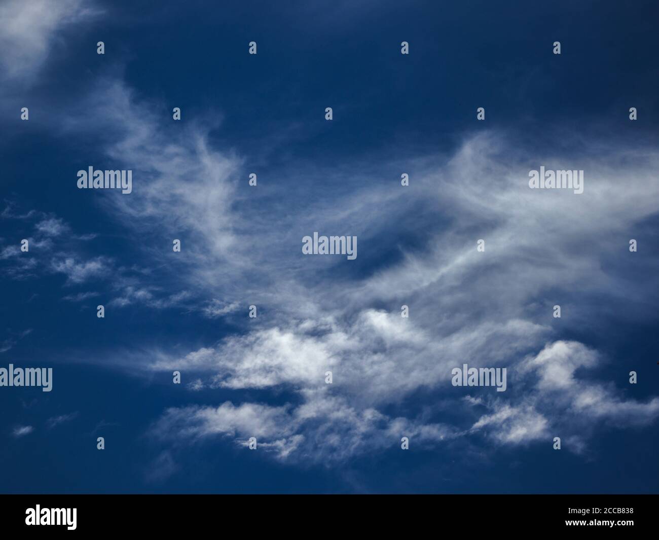 Schleier von dünnen Wolken von den Winden unter einem himmlischen blauen Himmel geblasen. Stockfoto