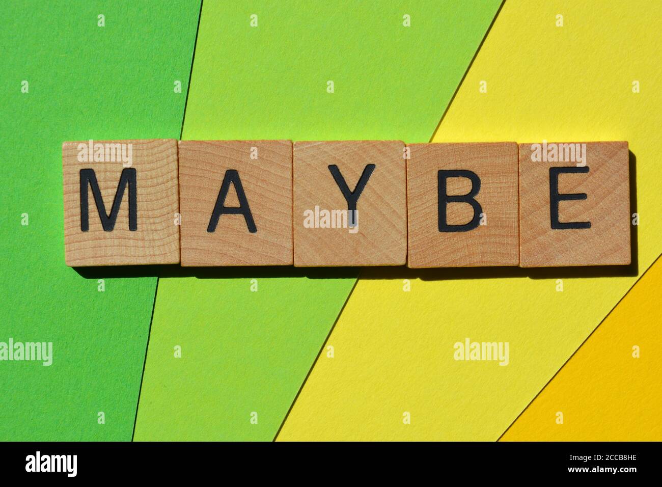 Vielleicht, Wort in Holzalphabet Buchstaben isoliert auf einem grünen Hintergrund Stockfoto