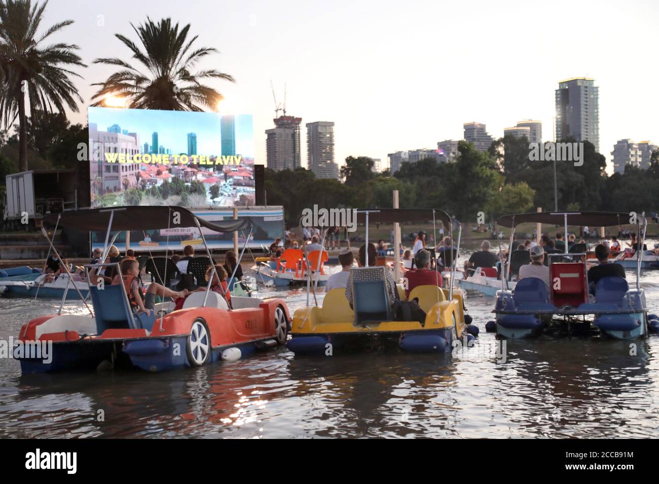 Tel Aviv, Israel. August 2020. Am 20. August 2020 sitzen Menschen in Booten, wie sie in einem schwimmenden Kino in Tel Aviv, Israel, sitzen. Das schwimmende Segelkino ist eine Initiative der Stadtverwaltung von Tel Aviv, um Menschen während der Beschränkungen der COVID-19-Pandemie kulturelle Veranstaltungen zu bieten. (Gideon Markowicz/JINI via Xinhua) Quelle: Xinhua/Alamy Live News Stockfoto