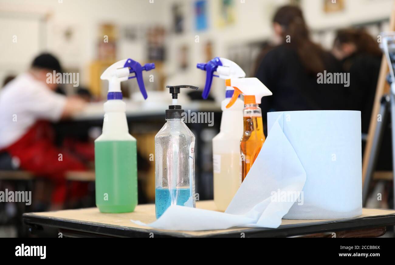 In einem covid sicheren Klassenzimmer in einer Schulumgebung. Reinigungs- und Hygieneprodukte, einschließlich Händedesinfektionsmittel und Sprühreinigungsprodukte auf einem Tisch Stockfoto