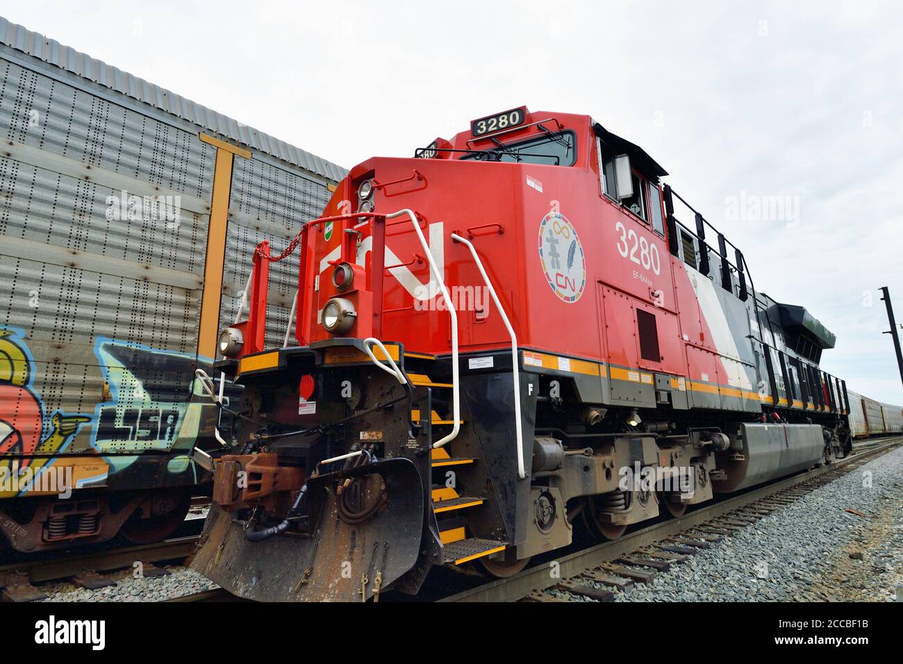 Homewood, Illinois, USA. Eine kanadische Nationallokomotive, die positioniert wird, um einen ausgehenden Güterzug zu führen, passiert einen anderen abfahrenden Güterzug. Stockfoto