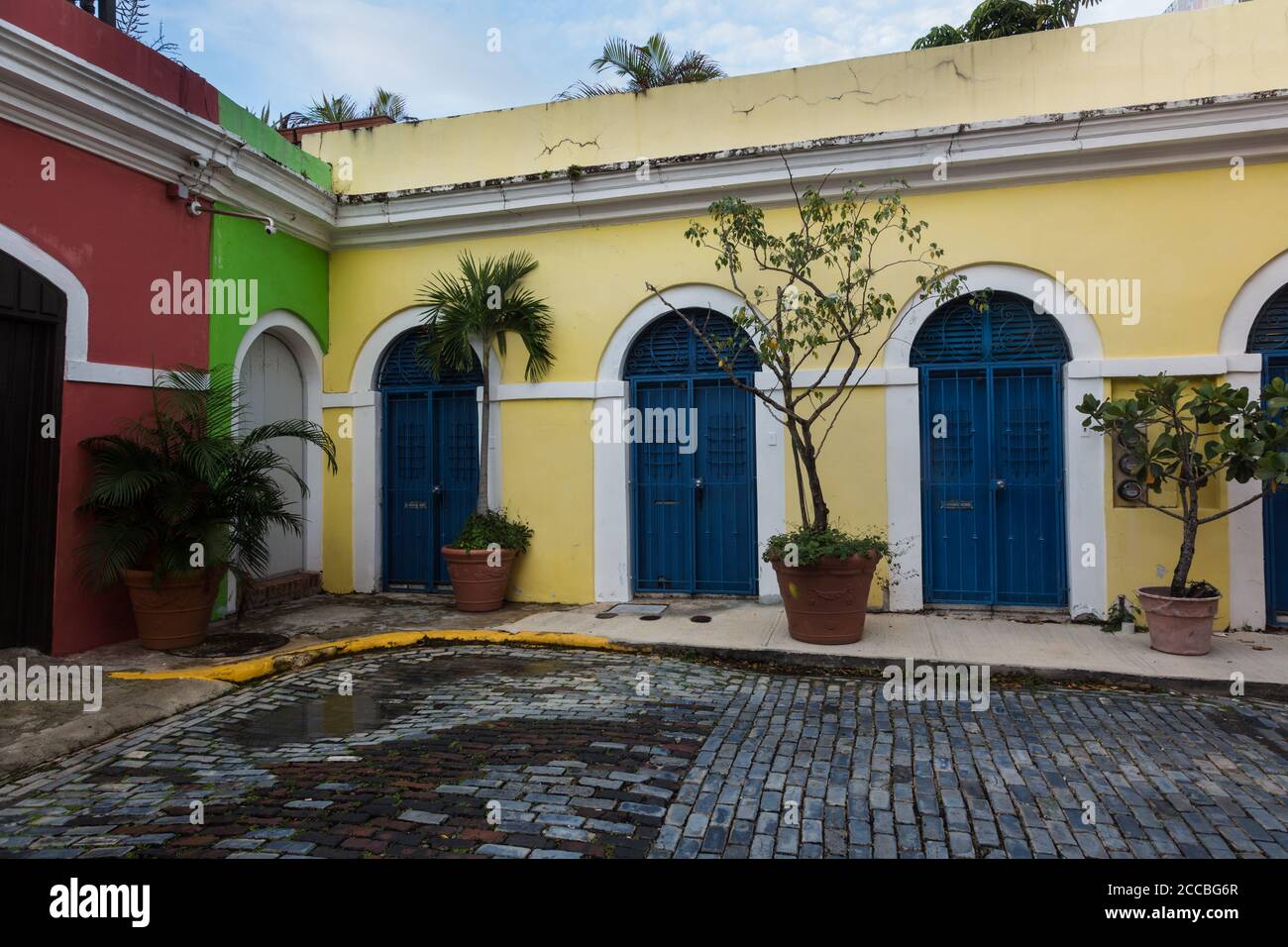 Bunt bemalte Häuser in einer engen Kopfsteinpflasterstraße in der historischen Kolonialstadt Old San Juan, Puerto Rico. Stockfoto