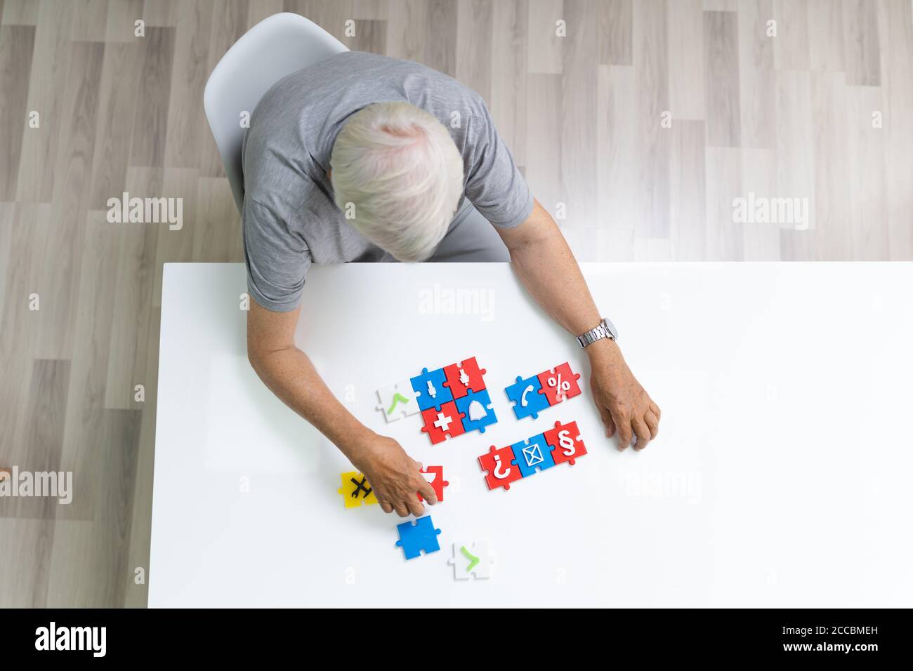 Ältester Mann Spielen Puzzle Auf Dem Tisch Stockfoto