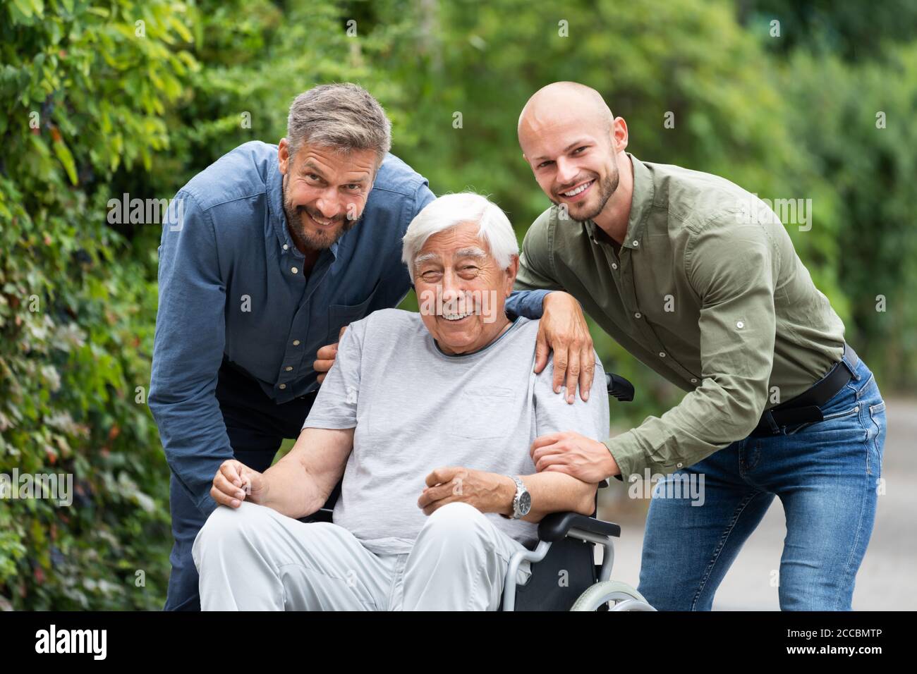 Alter Behinderter Großvater Im Rollstuhl Mit Fürsorglicher Familie Stockfoto