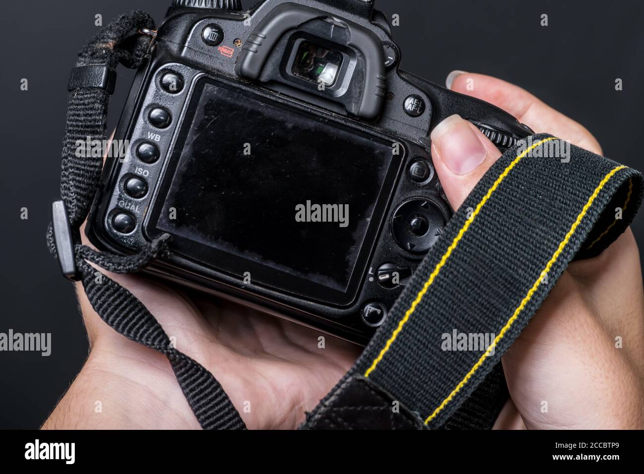 Eine Nahaufnahme einer alten Digitalkamera, die von menschlichen Händen gehalten wird. Stockfoto