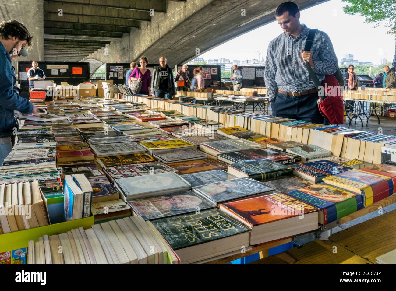 Leute, die an den Buchständen der Southbank unter der Waterloo Bridge in London stöbern. Stockfoto