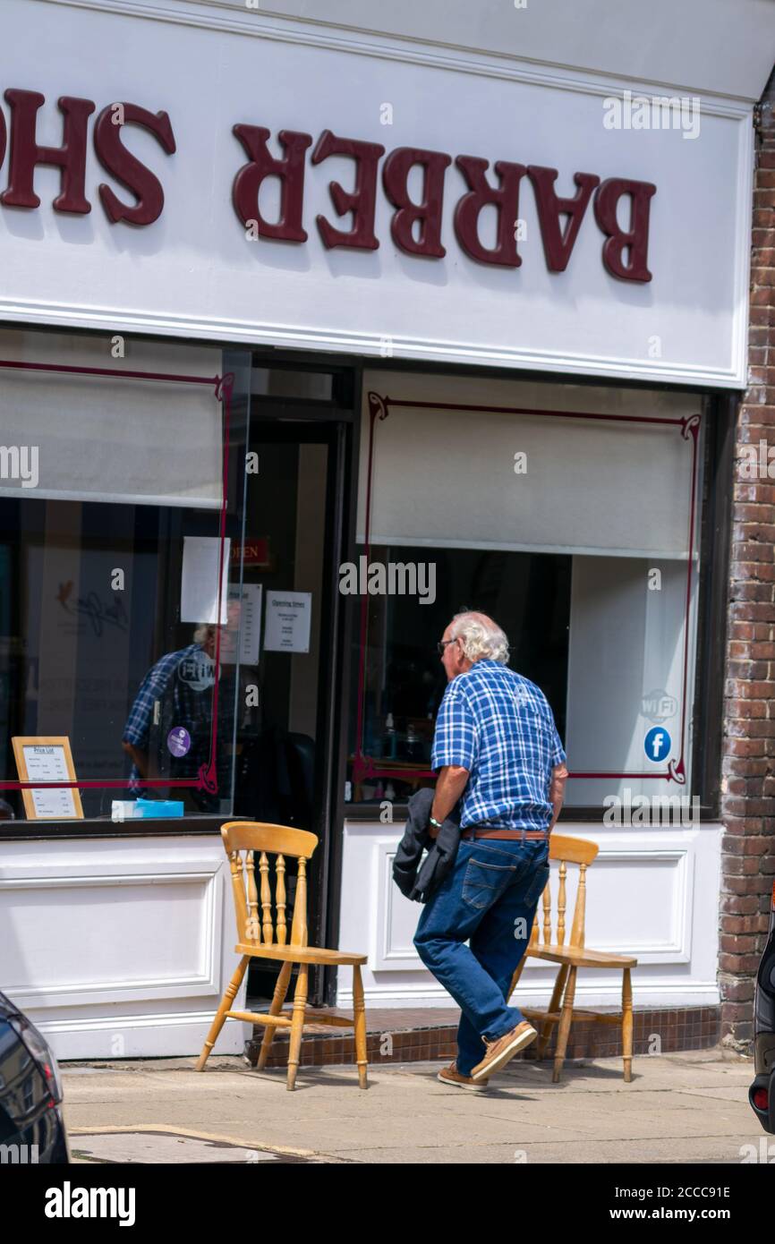 Winchester, Vereinigtes Königreich - 16. Juli 2020: Coiffeur Shop Friseur arbeitet während Pandemie Anwendung sozialer Distanzierung und PSA für Kunden und Crew Stockfoto