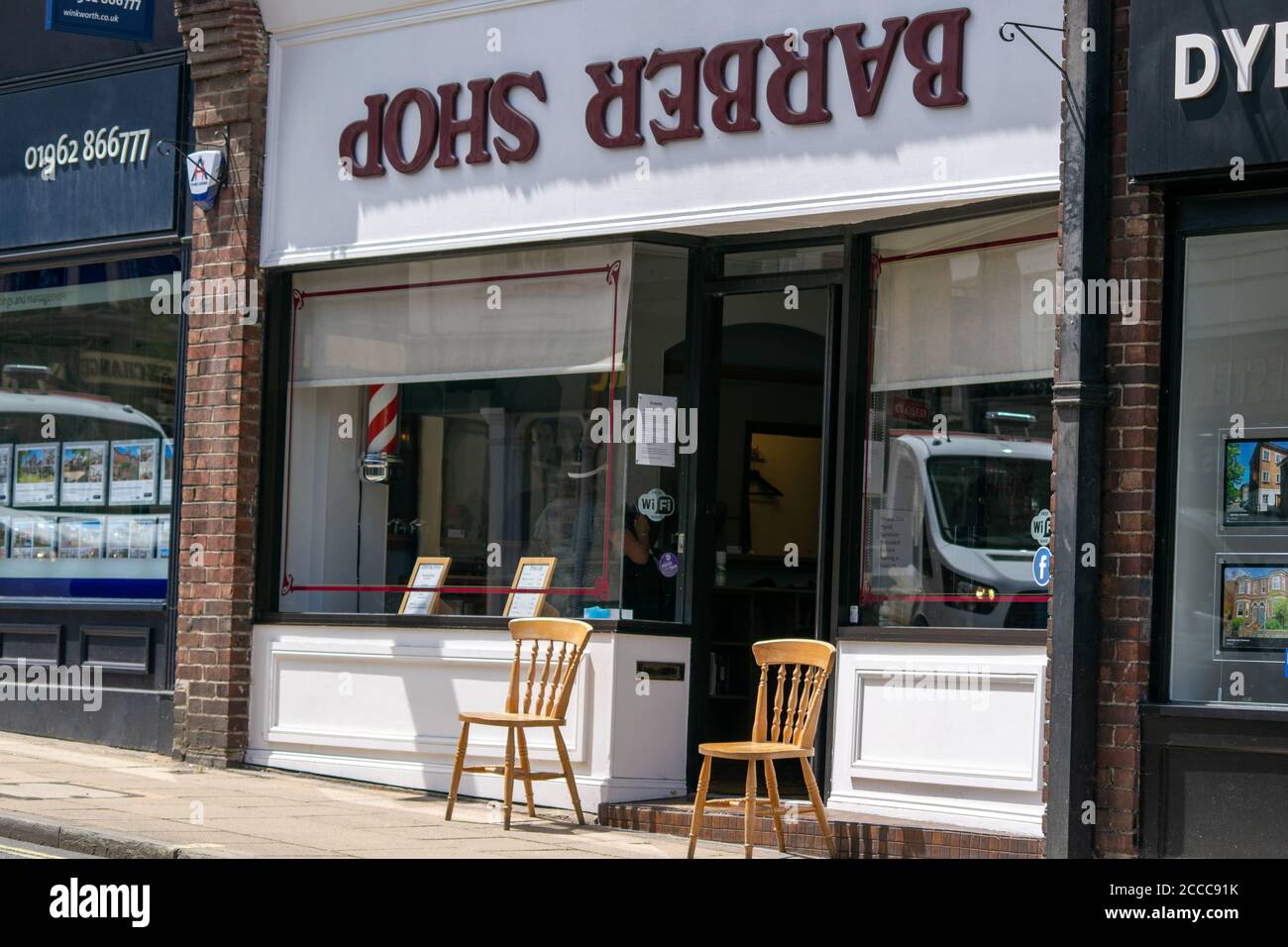 Winchester, Vereinigtes Königreich - 16. Juli 2020: Coiffeur Shop Friseur arbeitet während Pandemie Anwendung sozialer Distanzierung und PSA für Kunden und Crew Stockfoto