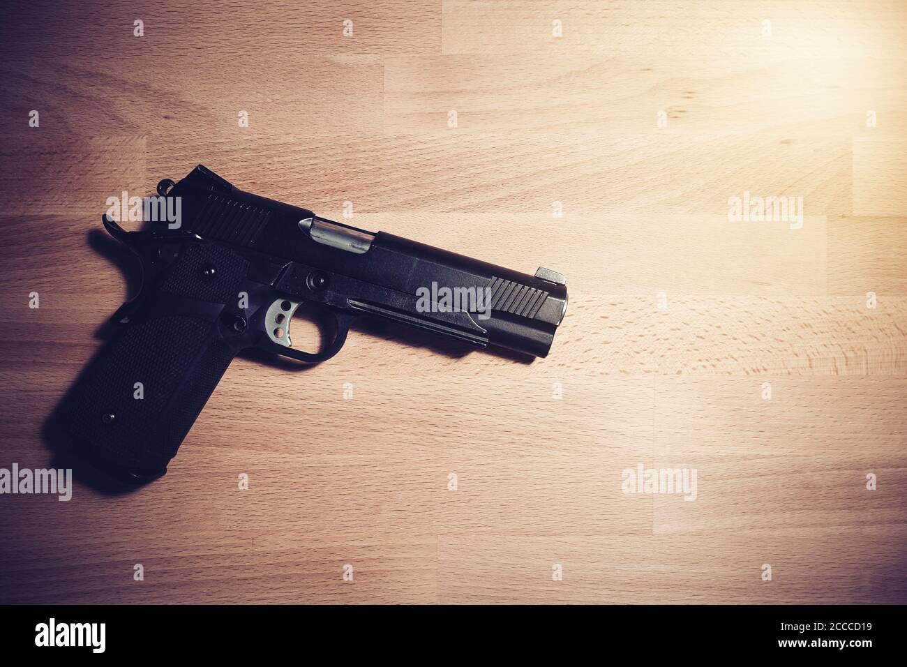Sicherheits- und Sicherheitskonzept: Schwarze Pistole auf einem Holztisch Stockfoto
