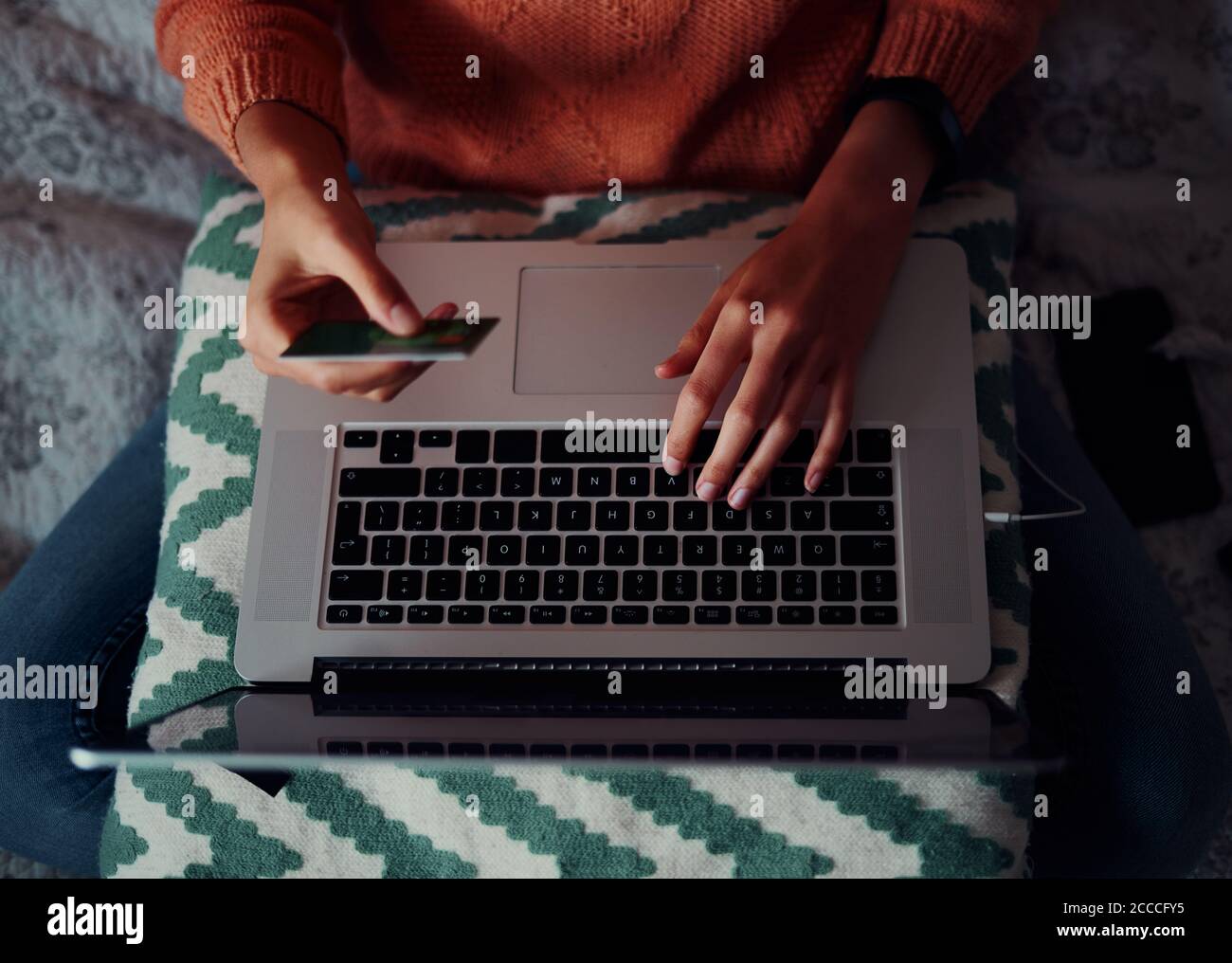 Nahaufnahme der jungen Frau, die eine Bann-Karte in der Hand hält Für die Online-Zahlung mit Laptop zu Hause Stockfoto