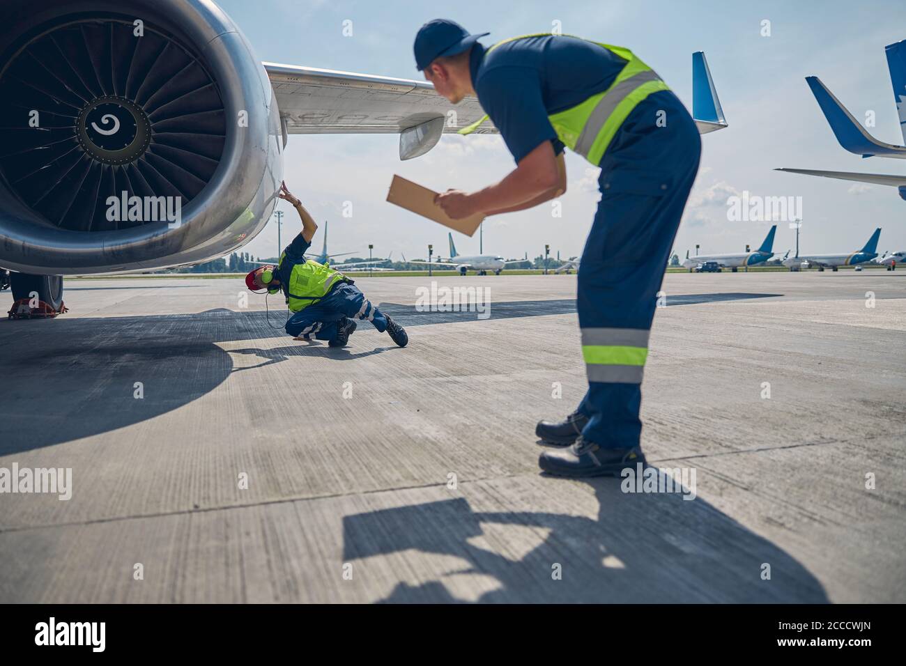 Professionelle Flugzeugmechaniker, die die Motorverkleidung inspizieren Stockfoto
