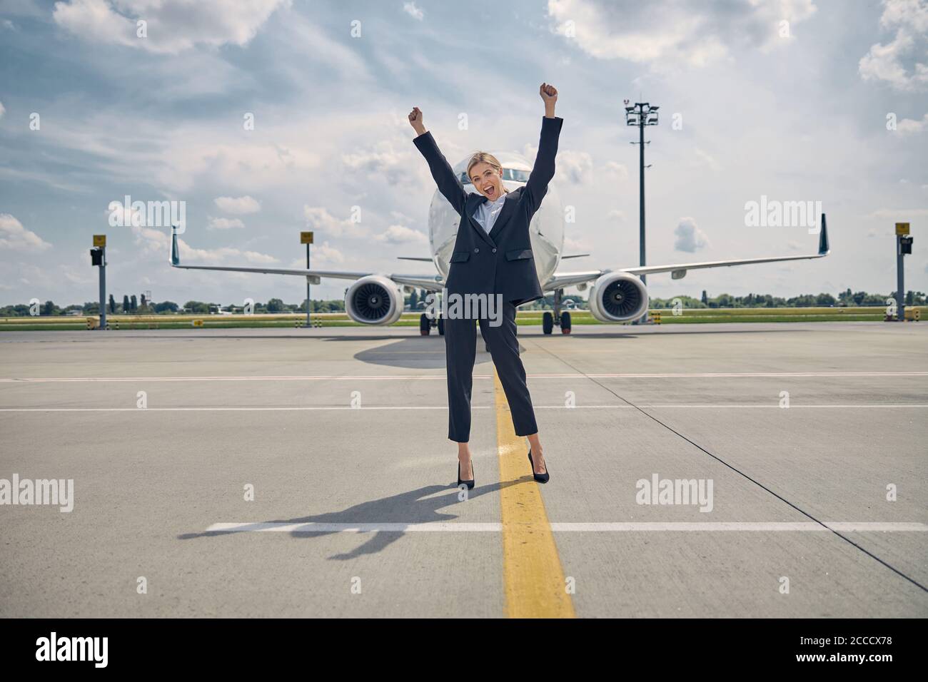 Glückliche junge Frau erwartet einen bevorstehenden Flug Stockfoto