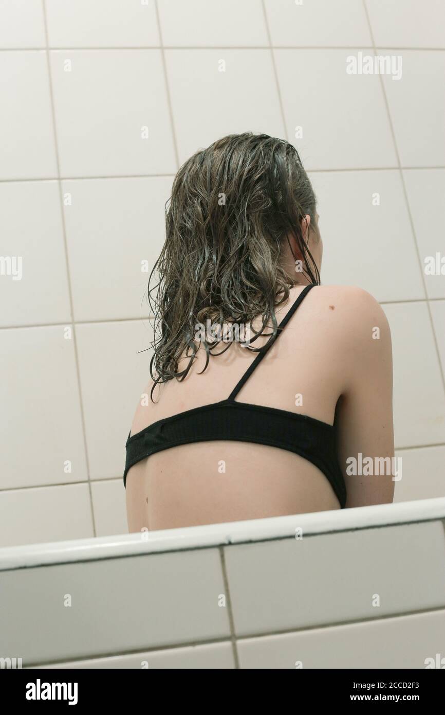 Mädchen mit nassem Haar in der Badewanne und schwarzen BH Stockfotografie -  Alamy