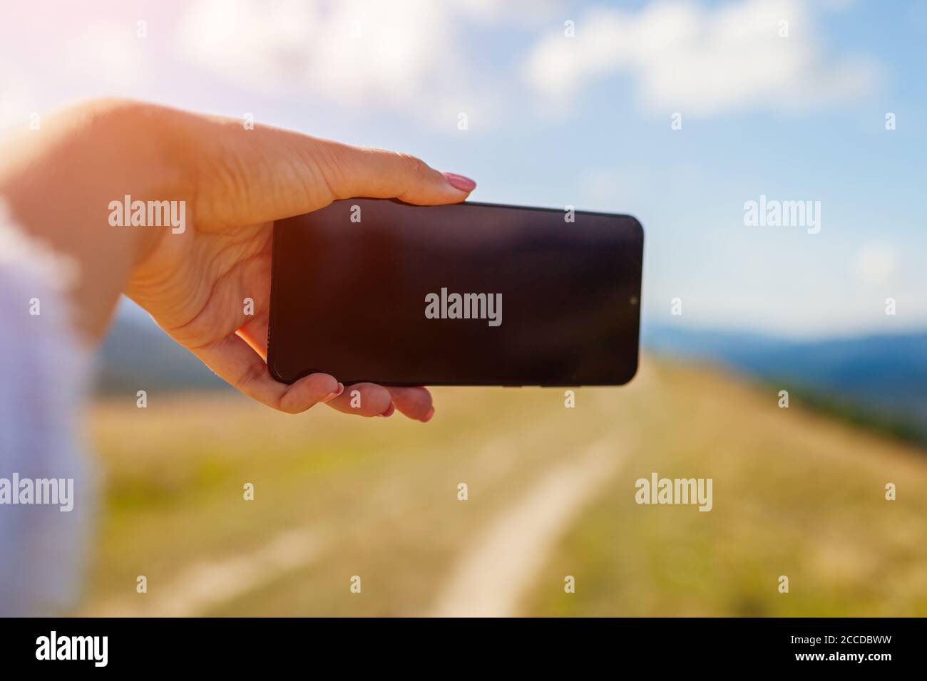 Frau Wanderer, die Selfie mit dem Smartphone in den Bergen auf dem Berggipfel. Nahaufnahme des Handybildschirms. Space Mockup Stockfoto