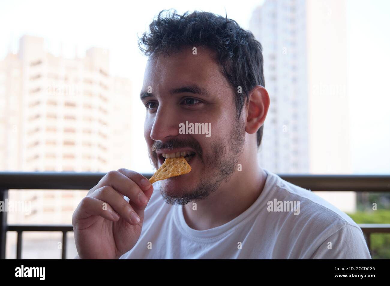 Junger Mann, der einen Snack isst. Ungesunde Gewohnheit. Stockfoto