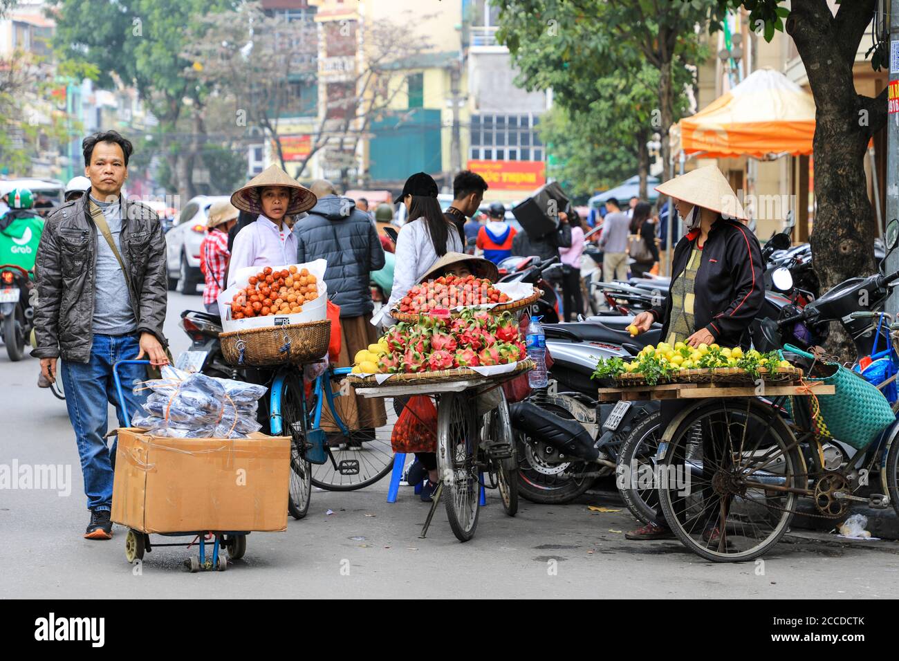 Händler oder Straßenverkäufer verkaufen Obst und Gemüse von Fahrrädern auf einer belebten Straße in Hanoi, Vietnam, Südostasien Stockfoto