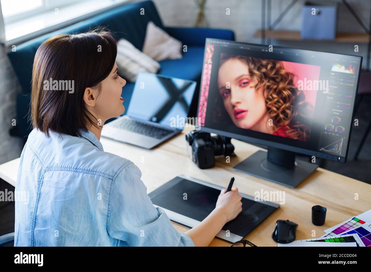 Porträt von Grafikdesigner arbeiten im Büro mit Laptop, Monitor, Grafik Zeichnung Tablette und Farbpalette.Retusche Bilder in einem speziellen Programm Stockfoto