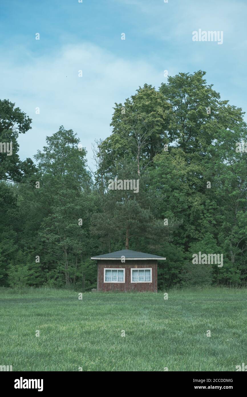 Traditionelles kleines skandinavisches Holzhaus am Waldrand. Typisches Sommerhaus. Land authentische gemütliche kleine Hütte in einer ländlichen Gegend Stockfoto