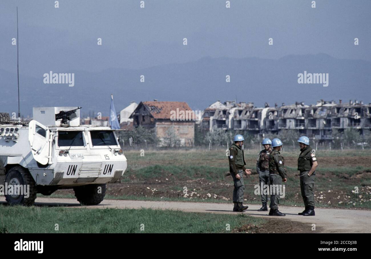 24. April 1994 während der Belagerung von Sarajevo: Auf einem Rollweg am Flughafen stehen ägyptische UNPROFOR-Soldaten in der Nähe der zerstörten Wohnblöcke von Dobrinja. Stockfoto