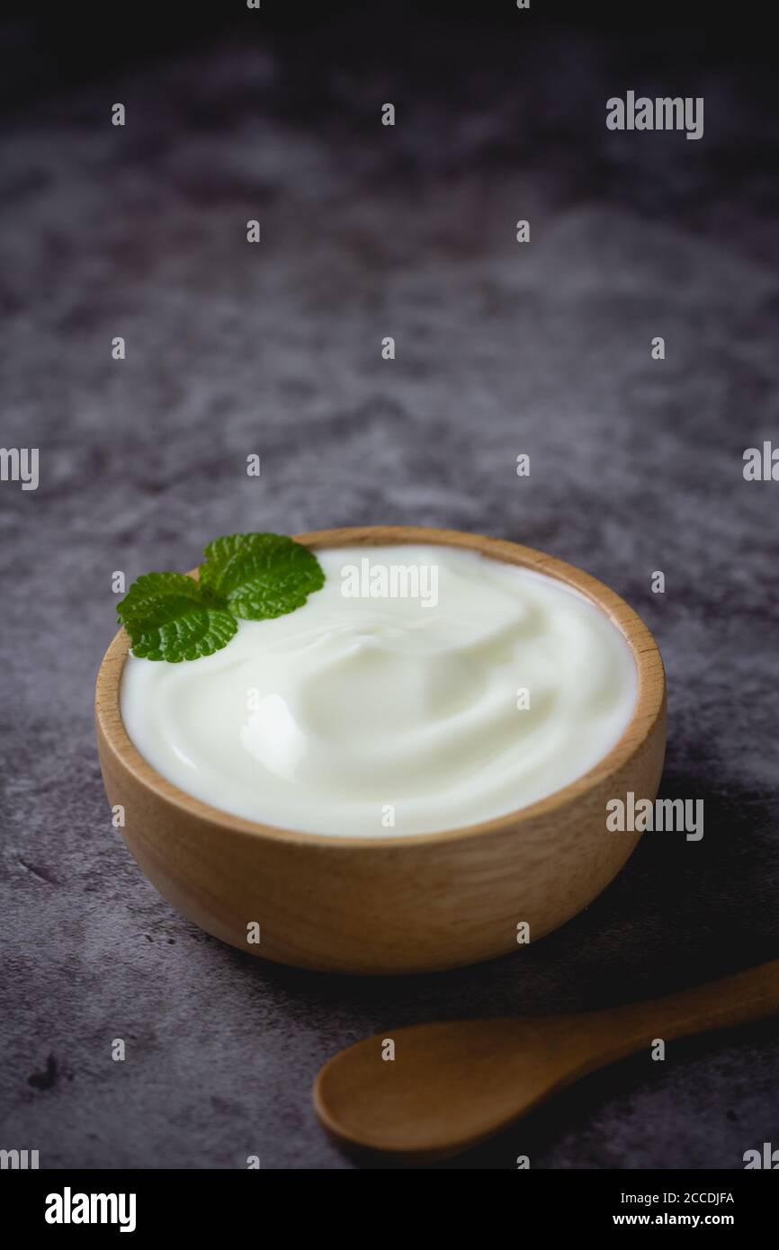 Naturjoghurt in Holzschale auf dem Tisch Stockfoto
