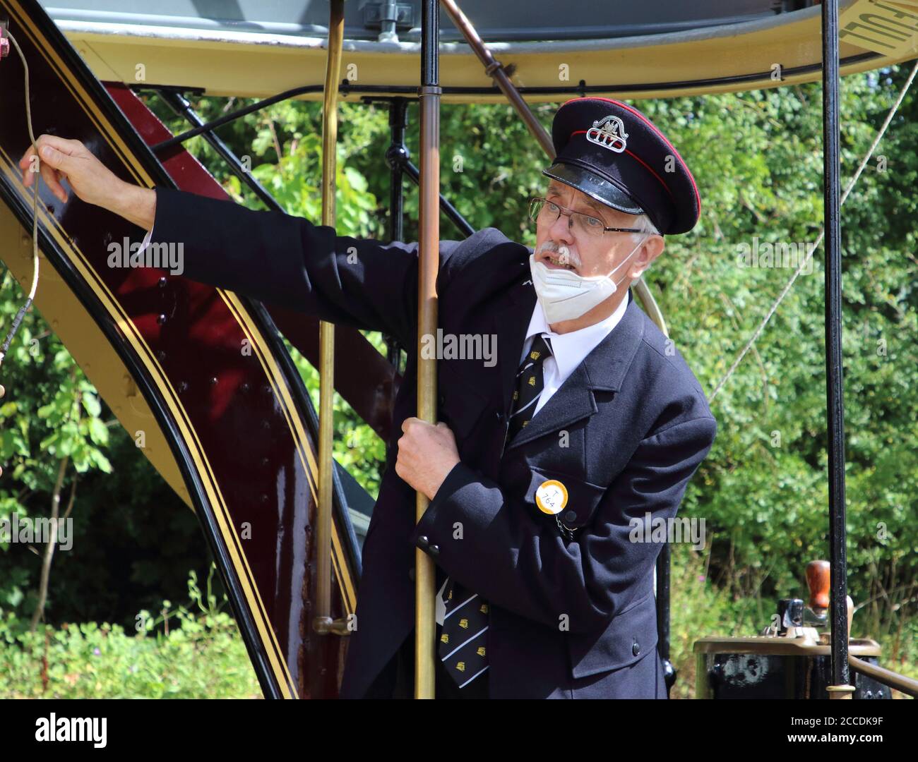 Derbyshire, Usa. August 2020. Ein Straßenbahnleiter läutet eine Glocke und kündigt an, dass es Zeit ist, abzureisen.Museen in Großbritannien wieder eröffnet mit schützenden Gesichtsmasken im Innenbereich erforderlich. Mit Gesichtsmasken, die bereits im öffentlichen Verkehr vorgeschrieben sind, erforderte das Fahren auf einer der Oldtimer-Straßenbahnen im National Tramway Museum in Crich Tramway Village Gesichtsbedeckungen sowohl von Fahrgästen als auch von Fahrern. Kredit: SOPA Images Limited/Alamy Live Nachrichten Stockfoto