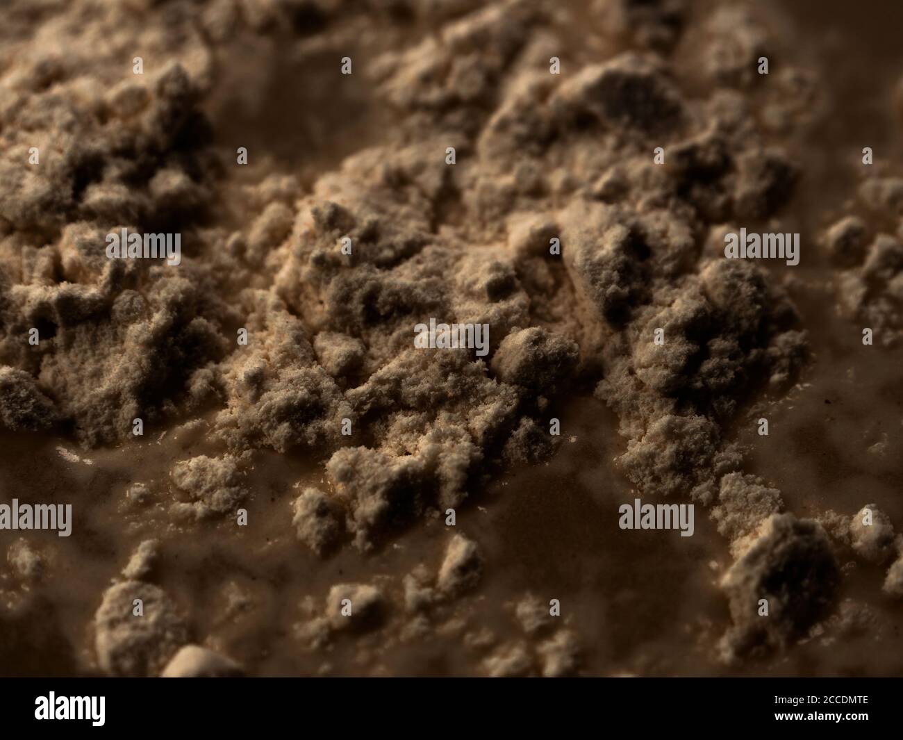 Abstrakte Oberfläche - zerklüfteter und rauer Haufen und Hügel aus brauner dunkler Substanz. Stockfoto