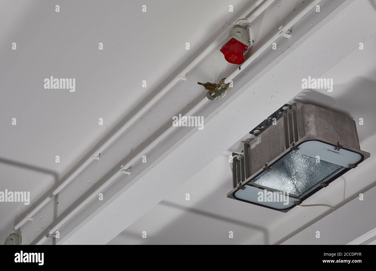 Industriedecke mit moderner Industriebeleuchtung und 16A-Stecker Stockfoto