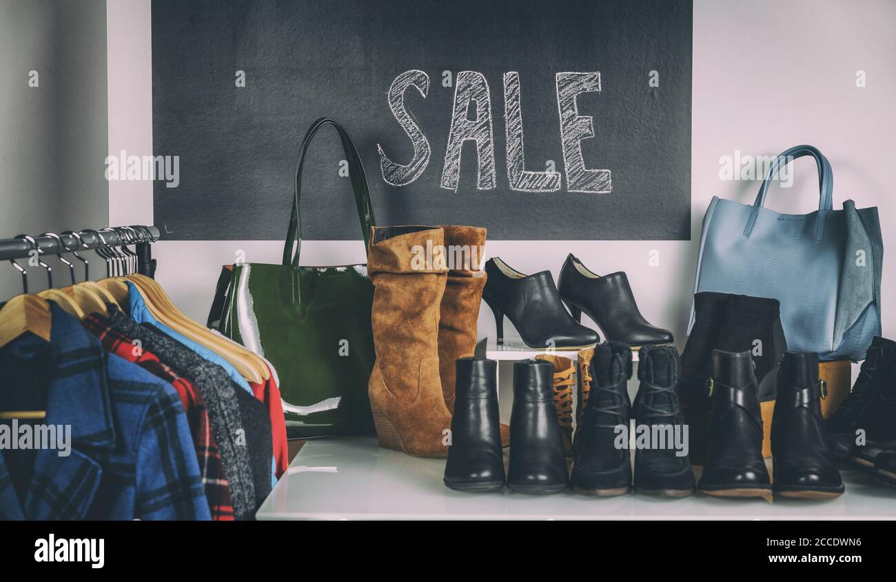 Shoe Shopping Verkauf von Schuhen und Winterstiefel in den Regalen. Verkauf Zeichen im Hintergrund mit Herbst Mäntel und Leder Booties für Frauen. Stockfoto