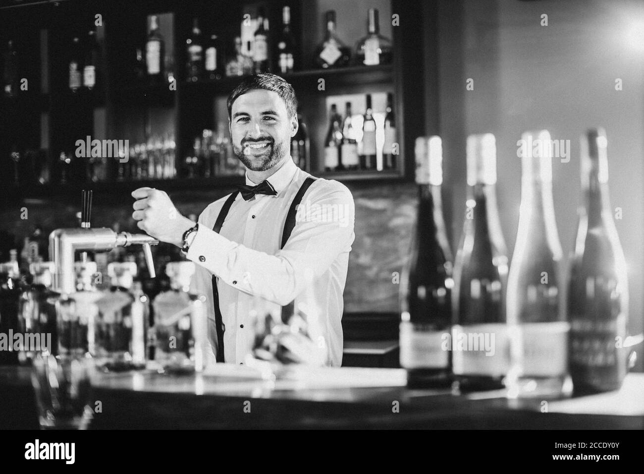 Barkeeper, Hosenträger, Fliege, lächelnd, Blick auf die Kamera Stockfoto