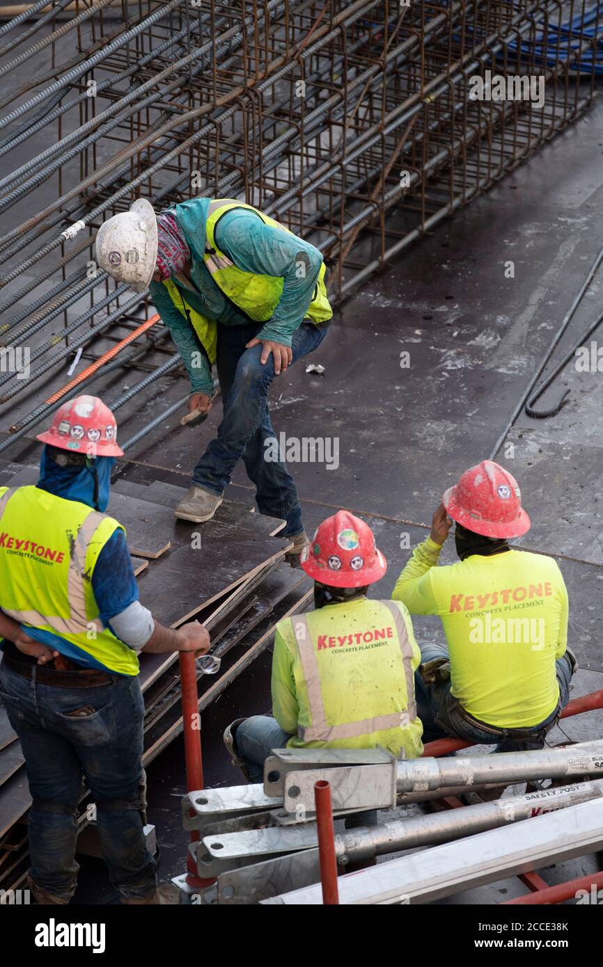 Austin, TX USA 25. Juli 2020: Die Betoncrew macht eine Pause, nachdem sie in der Tiefgarage eines 53-stöckigen Gebäudes bei einem nächtlichen Pausenausbruch in der Innenstadt von Austin, TX, gearbeitet hat. Trotz der landesweiten COVID-19-Pandemie und des Staates, der mit über einer halben Million Fällen und über 10,000 Todesfällen heimgesucht wird, werden in Texas weiterhin riesige Bauprojekte unvermindert durchgeführt. Stockfoto