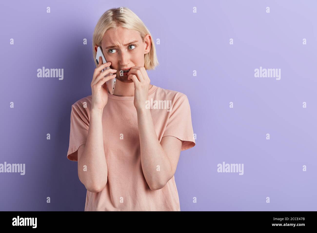 Nervös aufgeregt depressive Frau beißen Nägel beim Sprechen auf dem Smartphone, unglückliche Frau Probleme lösen, schlechte Nachrichten erhalten. Nahaufnahme Porträt, Isolat Stockfoto