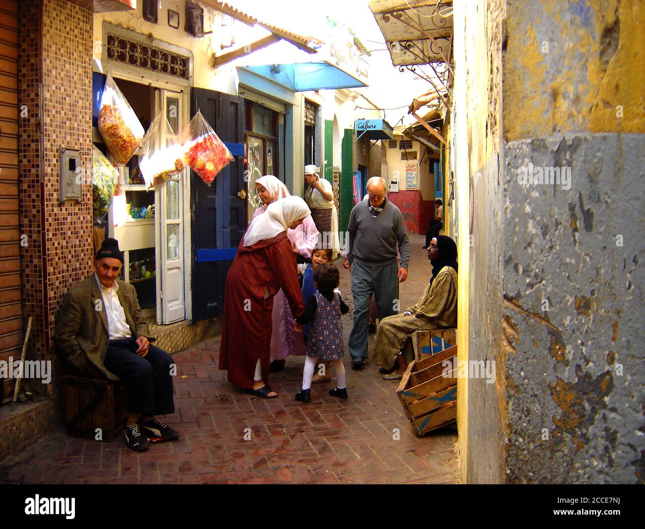 Oktober 2005 - die Medina ist ein von Mauern umschlossenes Gebiet mit einem Labyrinth aus Souks (Marktplätzen), Gassen, Geschäften und Handwerkern, die ihre Waren verkaufen. Beim Kauf geht es immer um Feilschen. Dieses Foto zeigt eine typische Straße mit kleinen Geschäften, in der Ladenbesitzer draußen sitzen und auf ihre Kunden in Tanger, Marokko, warten Stockfoto