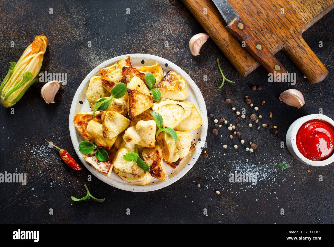 Gebratenes pattison und Sauce auf einem Tisch Stockfoto