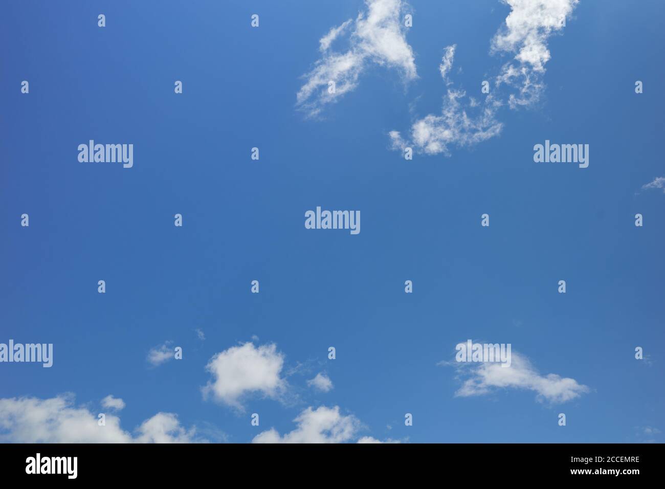 Zerrissene weiße Wolken am friedlichen blauen Himmel. Durchsichtiger blauer Himmel. Hintergrund für Vorhersage und Meteorologie Illustration Stockfoto