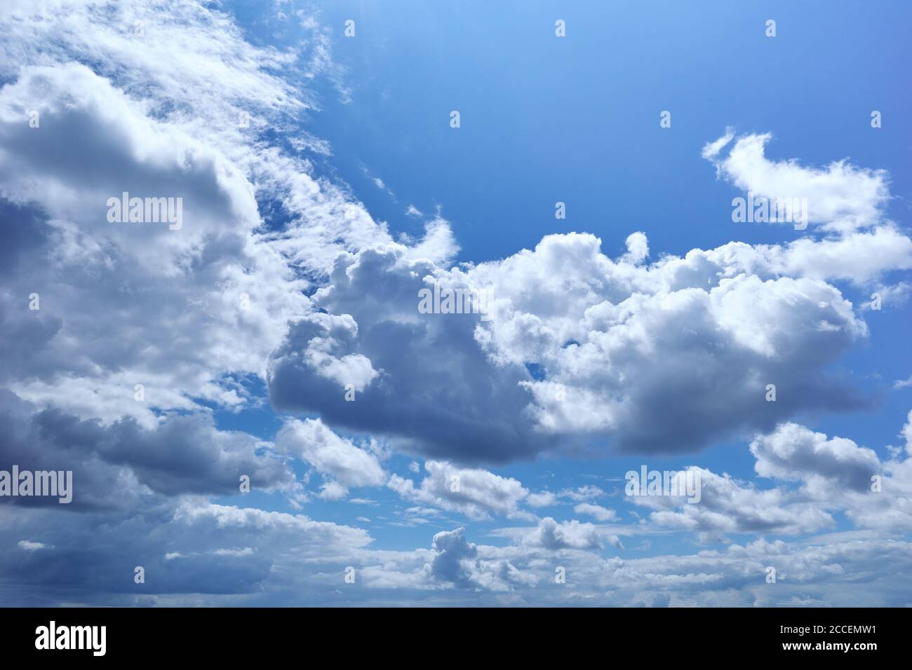 Blauer Himmel mit flauschigen Cumuluswolken, die wie Stücke von schwebender Baumwolle aussehen. Hintergrund für Vorhersage und Meteorologie Illustration Stockfoto