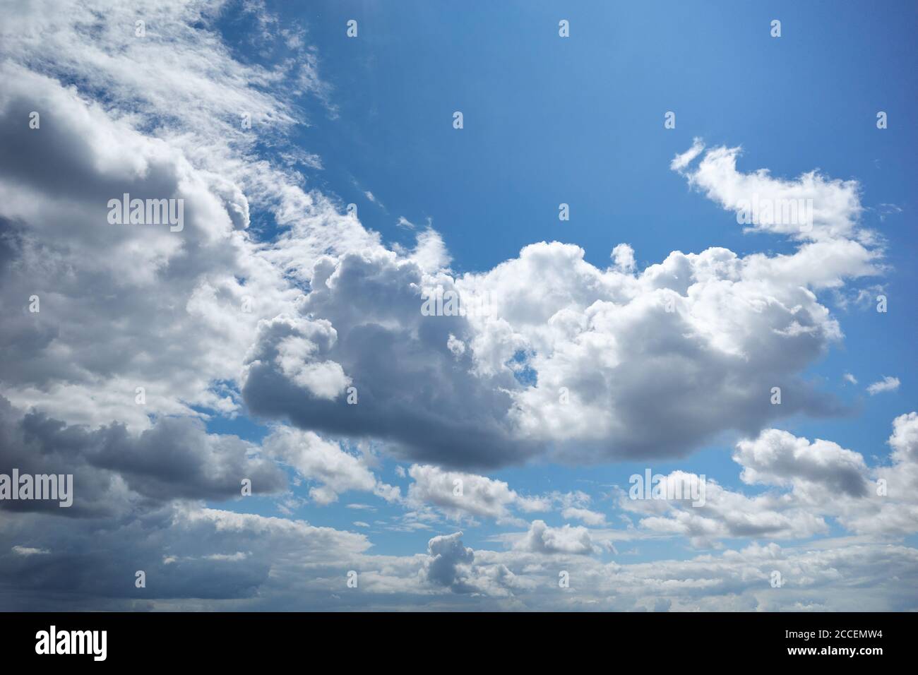 Strahlendes Blau des Himmels mit schönen, von der Sonne beleuchteten Cumuluswolken. Hintergrund für Vorhersage und Meteorologie Illustration Stockfoto