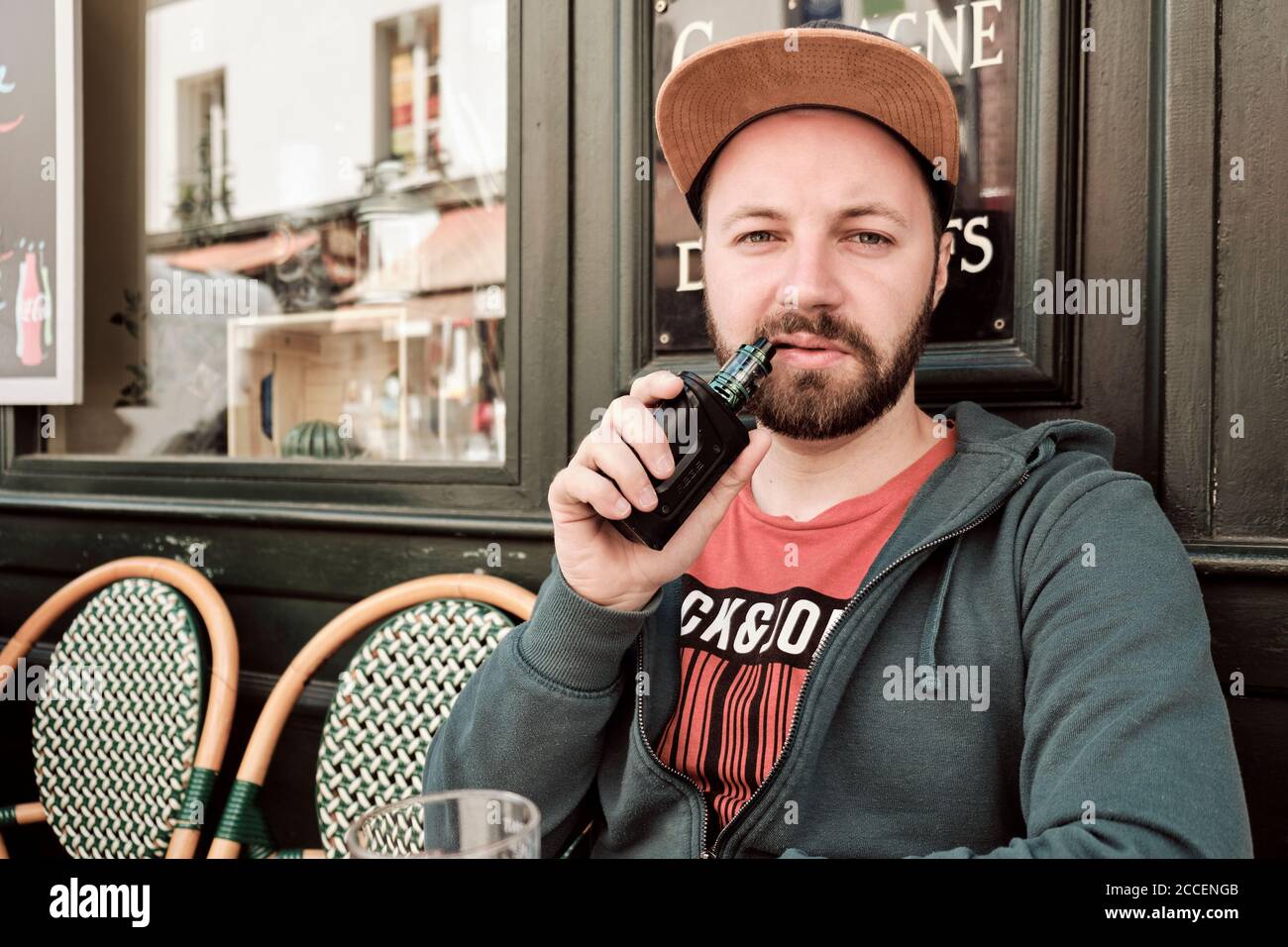 Europa, Frankreich, Paris, Montmartre, Sacre Coeur, junger Mann beim Rauchen/Verdampfen im Street Cafe, Stockfoto